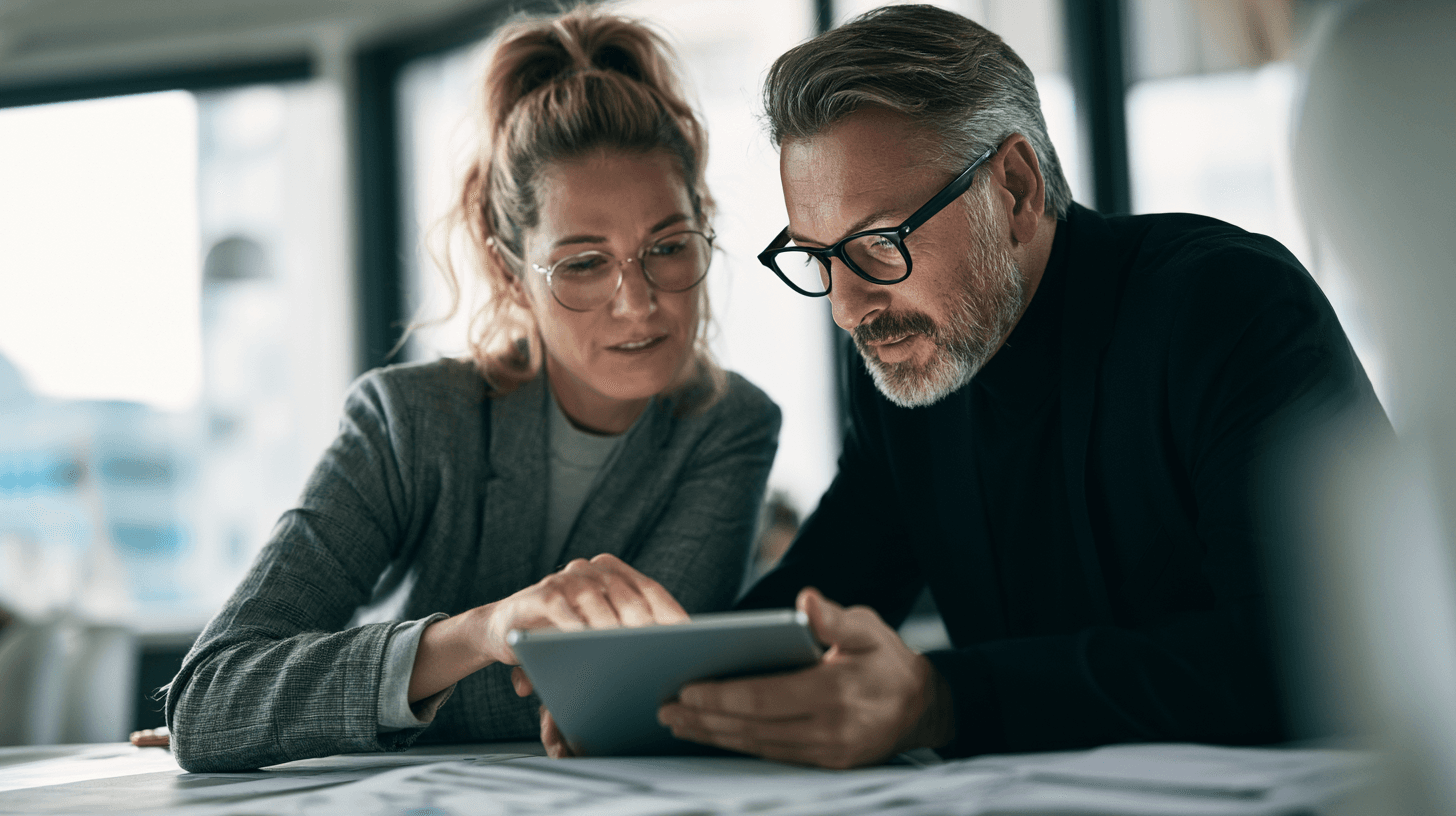 HR-Managerin und IT-Leiter prüfen eine Auswahl-Checkliste für Entgelttransparenz Software am Tablet